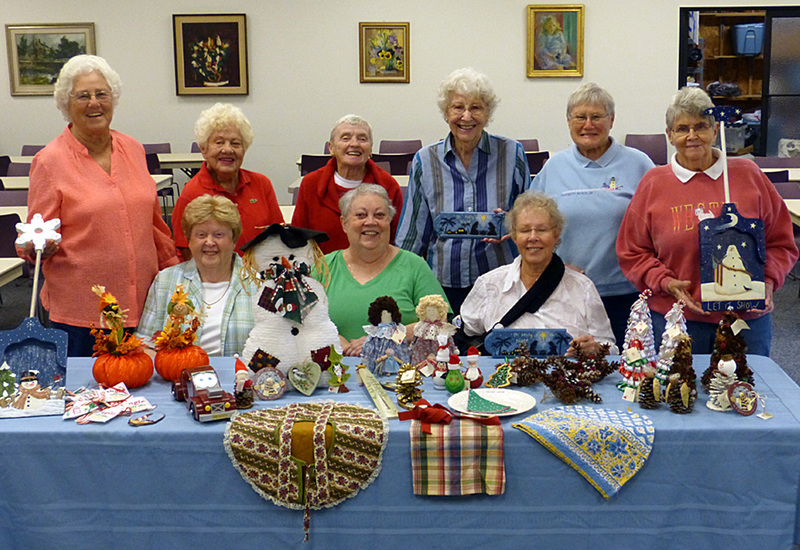 Organizers prepare for the St. George's Chapel Christmas Fair. Shown are in back (l-r) Liz Dixon, Lois Johnson, Pat Wolfe, professional artist Winnie Fullmer, and co-chairs Helen Abrams and Carol Welles. In front are Betty Hatfield, Cathy Graden and Cindy Kehl. SOURCE SUBMITTED